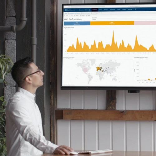 A man presents data in a Tableau dashboard